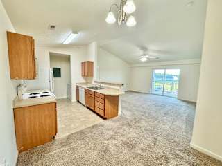 Cypress Upstairs Vaulted Living room & dining room with fan & carpeted floors  at Hawthorne Properties in Lafayette, IN 47905