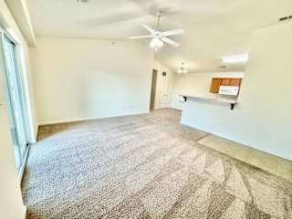 Cypress Upstairs Vaulted Living room & kitchen with fan & carpeted floors at Hawthorne Properties in Lafayette, IN 47905