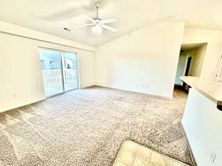 Cypress Upstairs Vaulted Living room & kitchen with fan & carpeted floors at Hawthorne Properties in Lafayette, IN 47905