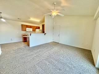 an empty living room with a ceiling fan and a kitchen at Hawthorne Properties in Lafayette, IN 47905