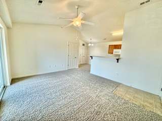 the living room and kitchen of an empty house with a ceiling fan at Hawthorne Properties in Lafayette, IN 47905