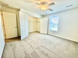 an empty living room with a ceiling fan and a closet at Hawthorne Properties in Lafayette, IN 47905