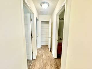 the hallway of a home with white walls and wood floors at Hawthorne Properties in Lafayette, IN 47905