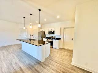 A kitchen with a black countertop and white cabinets.