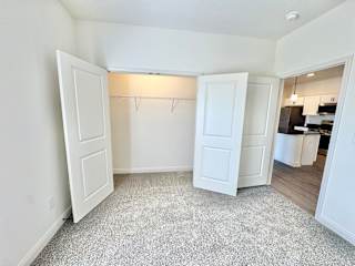 A white room with a grey carpet and a white door.