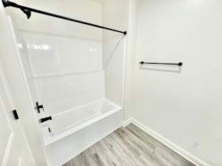 A white walk-in closet with a black rod and a white door.