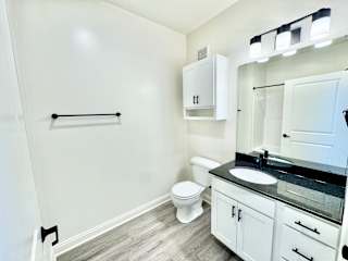 A bathroom with a toilet, sink, and medicine cabinet.