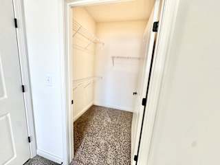 A white door is open to a small, empty room with a carpeted floor.