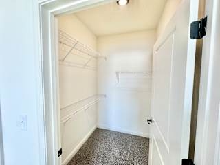 A white closet with a grey carpet and a white door.