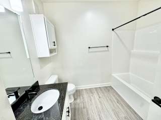 A bathroom with a sink, toilet, and bathtub.