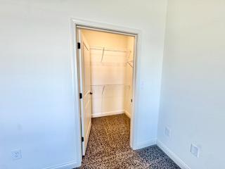 A white door with a black handle is open to a room with a carpeted floor.