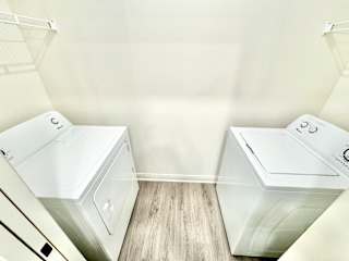 Two white washing machines in a laundry room.