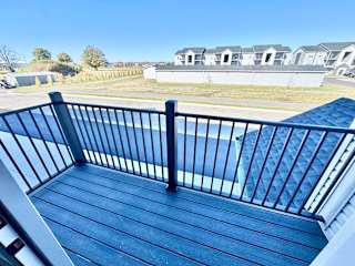 A balcony with a black railing and a blue wooden floor.