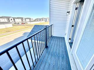 A balcony with a black railing and a blue wooden floor.