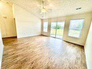 an empty living room with wood floors and a ceiling fan at Hawthorne Properties in Lafayette, IN 47905