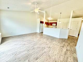 an empty living room with a ceiling fan and a kitchen at Hawthorne Properties in Lafayette, IN 47905