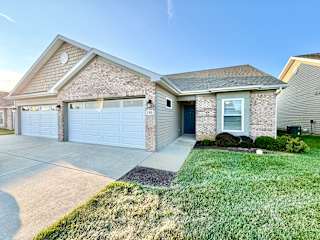 a house with a white garage door and a driveway at Hawthorne Properties in Lafayette, IN 47905