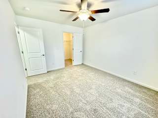 an empty living room with white walls and a ceiling fan at Hawthorne Properties in Lafayette, IN 47905