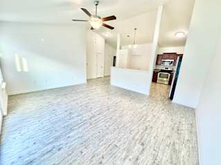 an empty living room with a ceiling fan and a kitchen at Hawthorne Properties in Lafayette, IN 47905