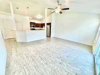 an empty living room and kitchen with a ceiling fan at Hawthorne Properties in Lafayette, IN 47905