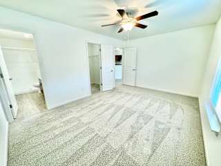 an empty living room with a ceiling fan and white walls at Hawthorne Properties in Lafayette, IN 47905