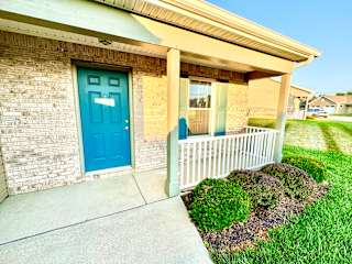 a blue door on the side of a building with a porch at Hawthorne Properties in Lafayette, IN 47905