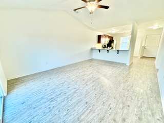 an empty living room with white walls and a ceiling fan at Hawthorne Properties in Lafayette, IN 47905