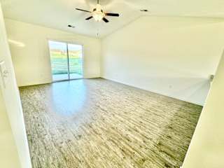 an empty living room with a ceiling fan and a window at Hawthorne Properties in Lafayette, IN 47905
