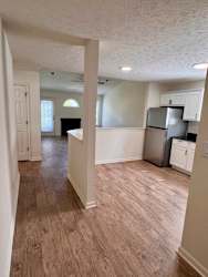 A kitchen with white cabinets and a refrigerator.