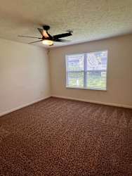 A room with a ceiling fan and a window.