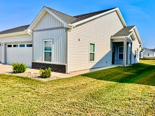 A house with a grey siding and a white garage door.