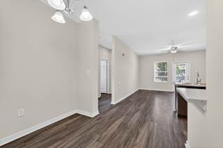 A room with wooden flooring and a ceiling fan.