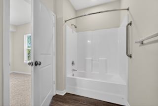 A white bathroom with a walk-in shower and a door.