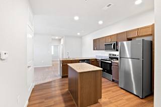 a kitchen with stainless steel appliances and wooden cabinets  at Aventura at Hawk Ridge, Lake St Louis