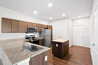 a kitchen with granite counter tops and stainless steel appliances at Aventura at Hawk Ridge, Missouri, 63367