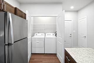 a renovated kitchen with white appliances and a washer and dryer  at Aventura at Hawk Ridge, Missouri, 63367