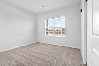 an empty room with carpet and a window  at Aventura at Hawk Ridge, Lake St Louis, Missouri