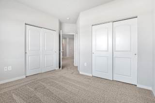a bedroom with white doors and carpeting and a hallway with white closets  at Aventura at Hawk Ridge, Missouri, 63367