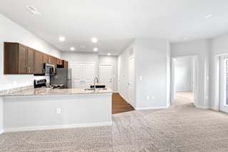 an open kitchen and living room with white walls and a white counter top  at Aventura at Hawk Ridge, Lake St Louis