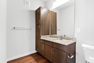 a bathroom with wooden cabinets and a toilet and a sink  at Aventura at Hawk Ridge, Lake St Louis, 63367