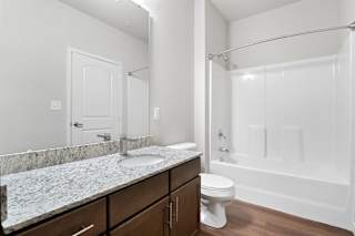 a bathroom with a shower toilet and sink and a mirror  at Aventura at Hawk Ridge, Lake St Louis, MO