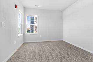 an empty room with carpet and two windows  at Aventura at Hawk Ridge, Lake St Louis, 63367