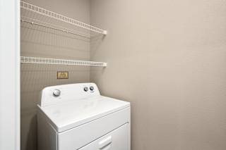 A white washing machine sits in a laundry room.