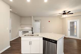 A kitchen with white cabinets and a granite countertop.