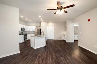 A modern kitchen with white appliances and a wooden floor.