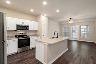 A kitchen with white cabinets and a black stove top oven.