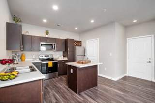 A kitchen with brown cabinets and a white counter at Aventura at Wentzville I & II Apartments, Wentzville, 63385