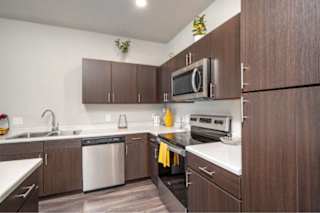 A kitchen with brown cabinets and a white counter top at Aventura at Wentzville I & II Apartments, Wentzville, MO