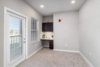 A room with a desk and a window with blinds at Aventura at Wentzville I & II Apartments, Wentzville