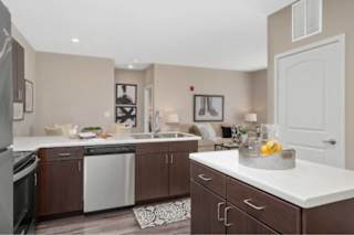 A kitchen with brown cabinets and a white countertop at Aventura at Wentzville I & II Apartments, Missouri, 63385